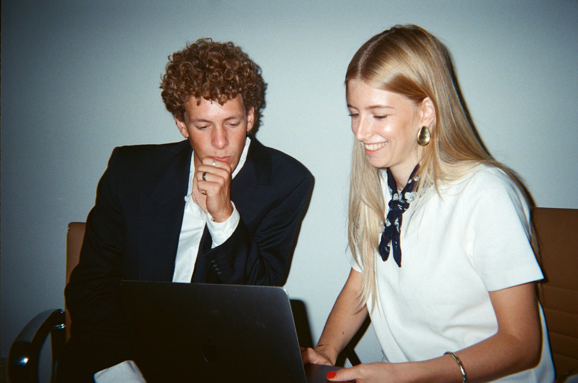 Twee collega's kijken samen naar een laptop